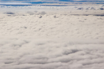 Beautiful cloudscape and blue sky from aerial view, nature view from above the sky and clouds. White clouds and blue sky view like the heaven from airplane window. Sunlight in the sky shines on clouds