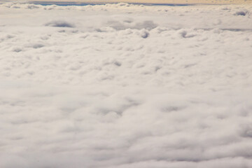 Beautiful cloudscape and blue sky from aerial view, nature view from above the sky and clouds. White clouds and blue sky view like the heaven from airplane window. Sunlight in the sky shines on clouds