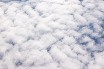 Beautiful cloudscape and blue sky from aerial view, nature view from above the sky and clouds. White clouds and blue sky view like the heaven from airplane window. Sunlight in the sky shines on clouds