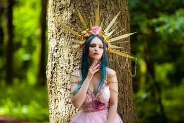 Costume Play. Magnificent Crowned Forest Nymph with Flowery Golden Crown Posing in Summer Forest...
