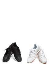 Black And White Concepts. Two Pairs of New Black and White Modern Sport Trainers Placed over Over White Background.