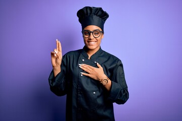 Young african american chef girl wearing cooker uniform and hat over purple background smiling...