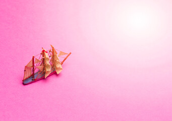 Travel Concepts. Scale Model of Three-Masted Sail Boat Placed Over Pink Background