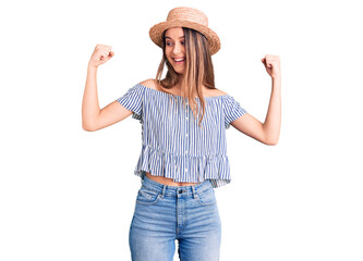 Obraz na płótnie Canvas Young beautiful girl wearing hat and t shirt showing arms muscles smiling proud. fitness concept.