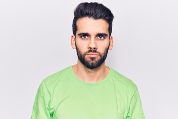 Fototapeta premium Young handsome man with beard wearing casual t-shirt with serious expression on face. simple and natural looking at the camera.