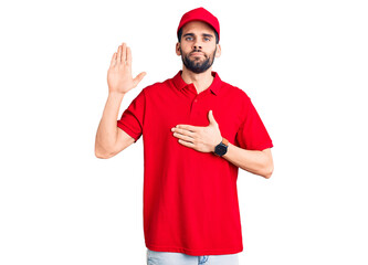 Young handsome man with beard wearing delivery uniform swearing with hand on chest and open palm,...
