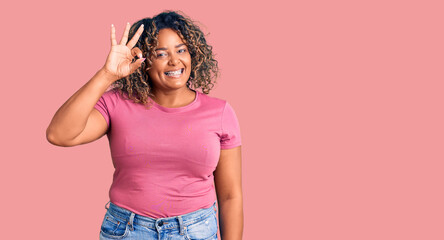 Young african american plus size woman wearing casual clothes smiling positive doing ok sign with hand and fingers. successful expression.