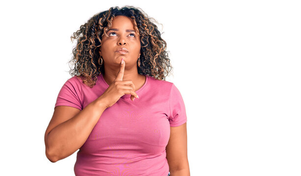 Young african american plus size woman wearing casual clothes thinking concentrated about doubt with finger on chin and looking up wondering