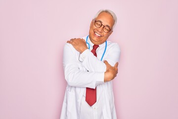 Middle age senior grey-haired doctor man wearing stethoscope and professional medical coat Hugging...