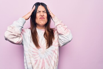 Fototapeta na wymiar Young beautiful brunette woman wearing casual dyed sweatshirt over isolated pink background with hand on head, headache because stress. Suffering migraine.