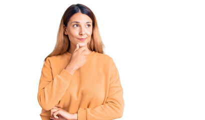 Beautiful young woman wearing casual clothes with hand on chin thinking about question, pensive expression. smiling with thoughtful face. doubt concept.