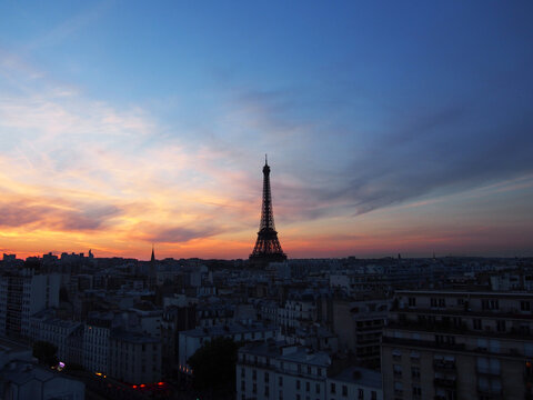 Paris skyline with an impressive Eiffel Tower in the pleasant sunset sky.