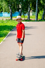 boy in a red T-shirt riding a skateboard in the park