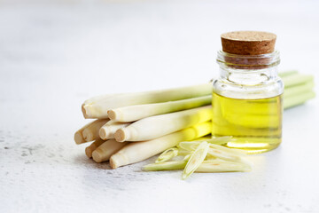 lemongrass essential oil and fresh lemongrass on the white marble table