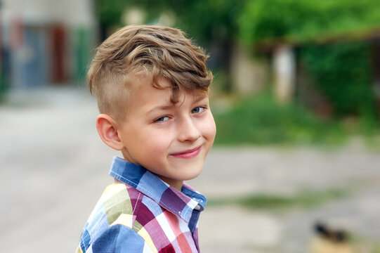 Portrait of a little boy with a fashionable hairstyle on the street