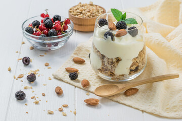 A dish of yogurt, granola, black raspberries and almonds.
