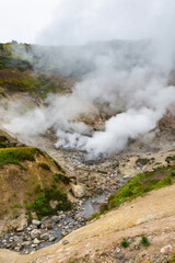 Exciting view of volcanic landscape, eruption fumarole, aggressive hot spring, gas-steam activity in crater of active volcano. Beautiful mountain landscape, travel destinations for active vacation.