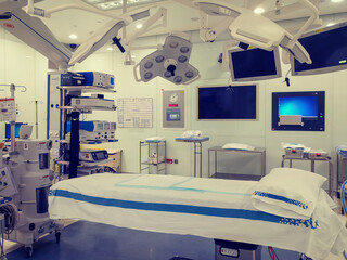 Operating theater  (room) in a modern hospital interior shot with bed in the middle and anesthesiology equipment. no people