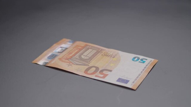 Revealing real Euro banknote under a medical mask ang covering the money again.