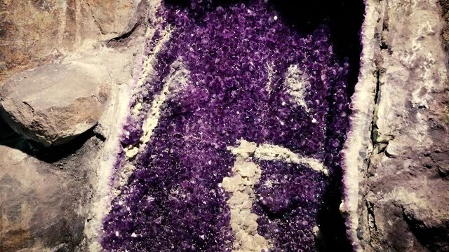 Natural amethyst gemstone within rock. Handheld. Pedestal shot.