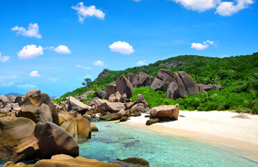 Anse Marron beach with big granite boulders on La Digue Island, Seychelles. Tropical landscape with sunny sky. Luxury travel destination.