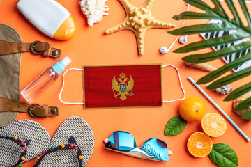 Accessories for beach holidays around a protective mask with the flag of Montenegro. Concept of leisure at sea during a pandemic. Top view