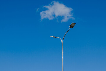 Street lantern on sky with white clouds background. A modern street LED lighting pole. Copy space