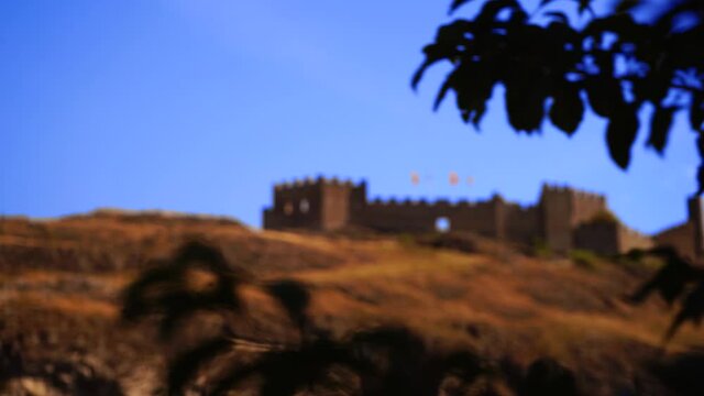 Reveal shot of Chateau de Tourbillon epic fortress wall on hill in Swiss Alps