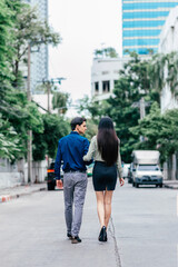 Fototapeta na wymiar Romantic moments. Full length shot of beautiful well dressed couple, going for a walk outdoors. Love, relationship, dating concept. Rear view. Vertical shot