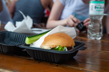 An open container with a hamburger on the table
