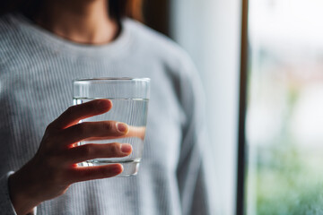 Closeup image of a woman holding a glass of pure water