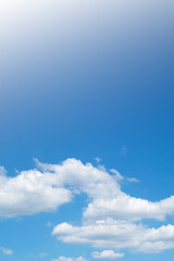 Beautiful sunny blue sky background with cotton candy white cumulus clouds & natural puffy fluffy cloudscape in tropical summer or spring sunlight & sun rays on bright daylight horizon at sunshine day