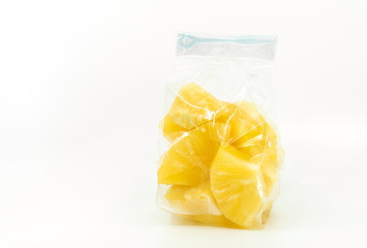 Fresh pineapple in cleared plastic bag or packaging with small fork for sell. Cut fresh pineapple in bite size. Image on white background.