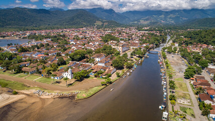 Fototapeta na wymiar Aerial view to river Pereque-Acu in historic town Paraty with green mountains covered with white clouds in background, Unesco World Heritage, Brazil