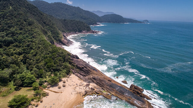 Aerial view to wonderful Green Coast shoreline with rock slabs, beach and mountains covered with Atlantic Forest, Picinguaba, Brazil
