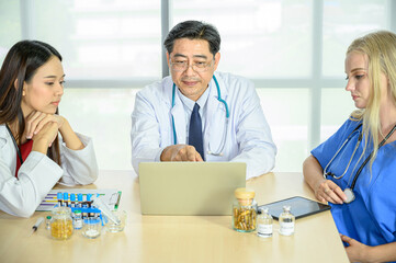 Obraz premium Group of doctors wearing formal white coat and blue scrubs suit, Teamwork brainstorm meeting with computer laptop at the hospital.