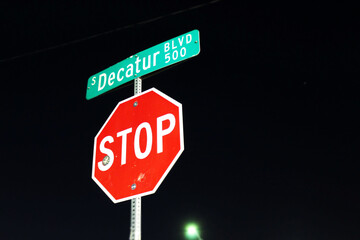 stop sign by street sign at night