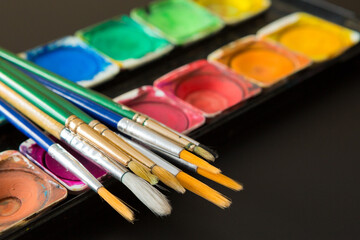 Colorful of Watercolor palette and paintbrush  on a black background