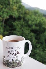 Coffee mug with inspirational message with nature background. Every day is a fresh start. Copy space.