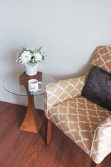 Cozy corner with arm chair, table, flower pot and coffee mug with inspirational message - background