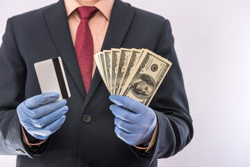 concept of security when paying for a product or service, businessman holding money and credit card in gloves