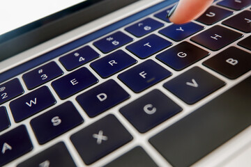Closeup of laptop keyboard with finger typing