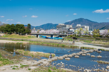 Fototapeta na wymiar Beautiful scenic view from Kamo River (Kamo-gawa) in Kyoto, Japan. The riverbanks are popular walking spots for residents and tourists.
