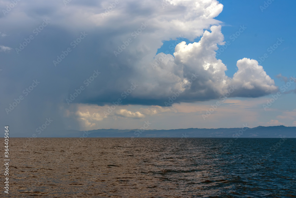 Sticker Calm tropical sea under darkening storm clouds