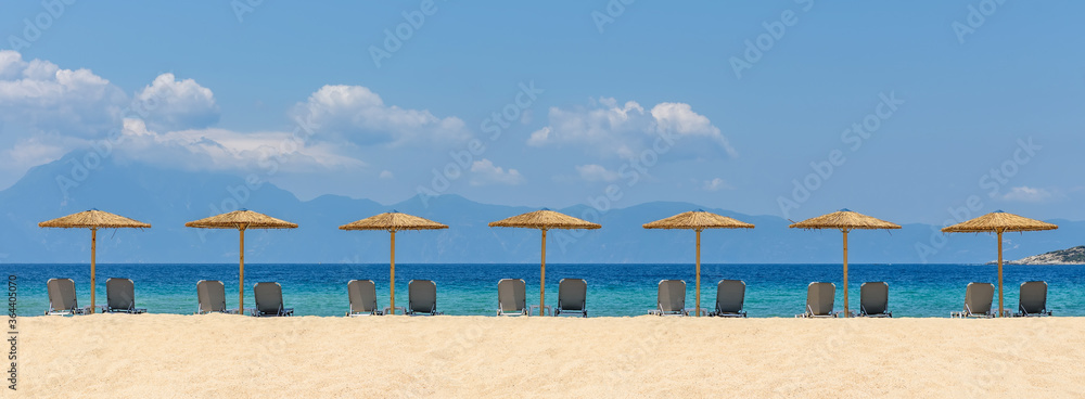 Wall mural beach chairs with umbrella with blue sky