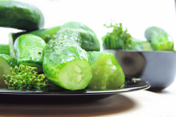   slightly pickled cucumber on a black plates , summer salting      