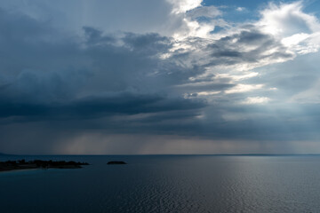 Calm tropical sea under darkening storm storm clouds