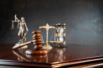 Law symbols composition. Themis statue, judge’s gavel and scale of justice on shining brown table...