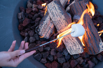 Roasting marshmallow over a gas fire while glamping