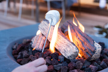 Roasting marshmallow over a gas fire while glamping